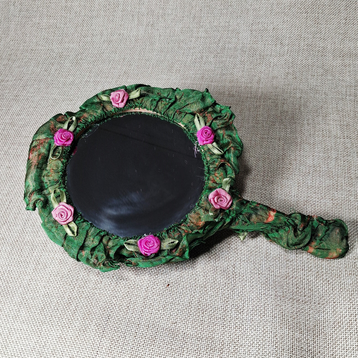 Vintage Hand Mirror: Unique and Hand Made with Fabric Roses on a Green Background