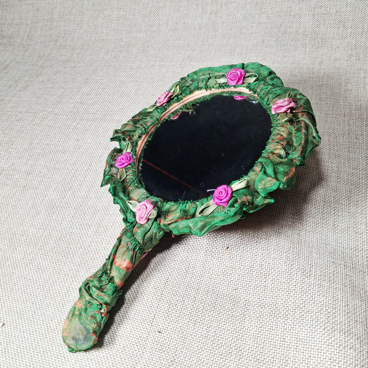 Vintage Hand Mirror: Unique and Hand Made with Fabric Roses on a Green Background