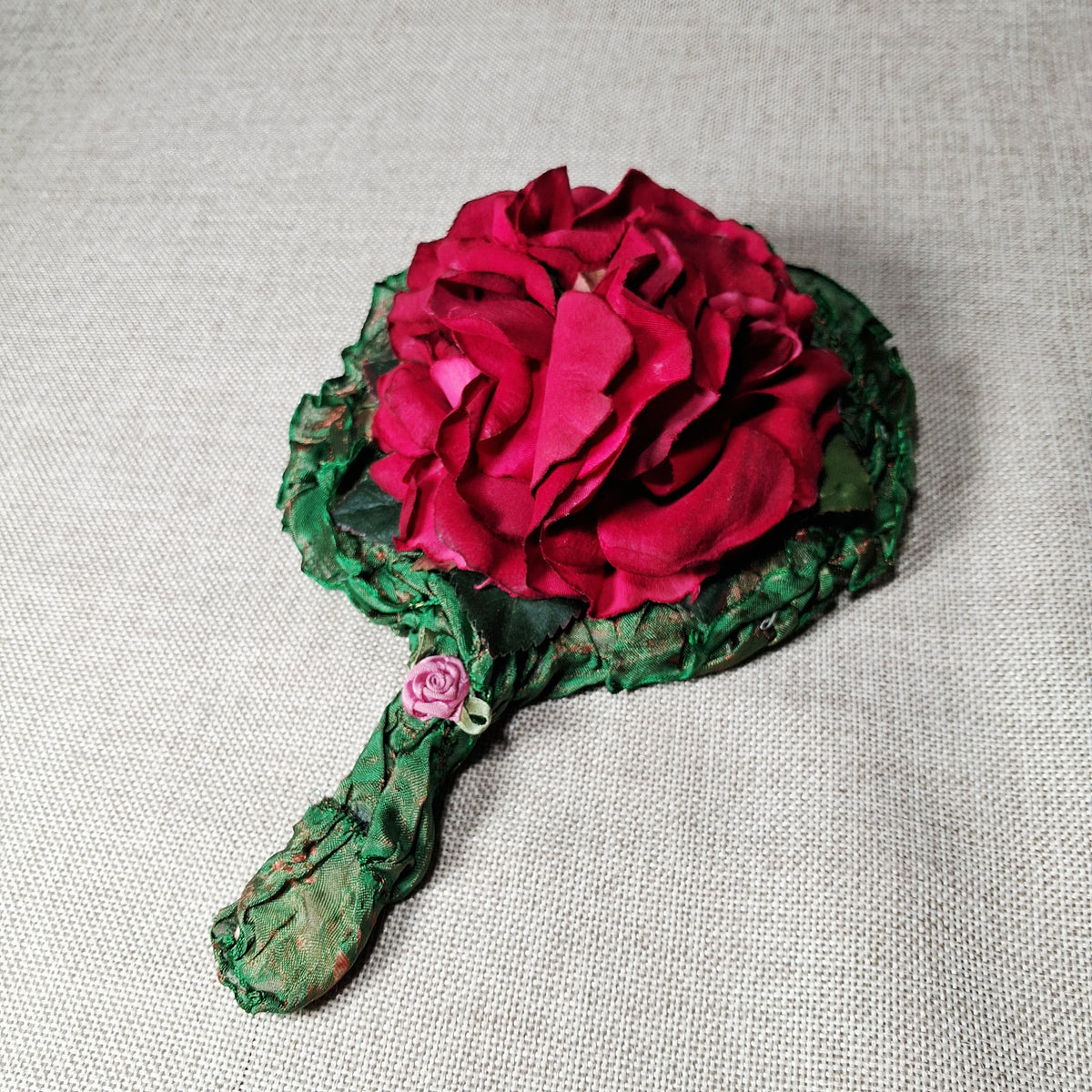 Vintage Hand Mirror: Unique and Hand Made with Fabric Roses on a Green Background